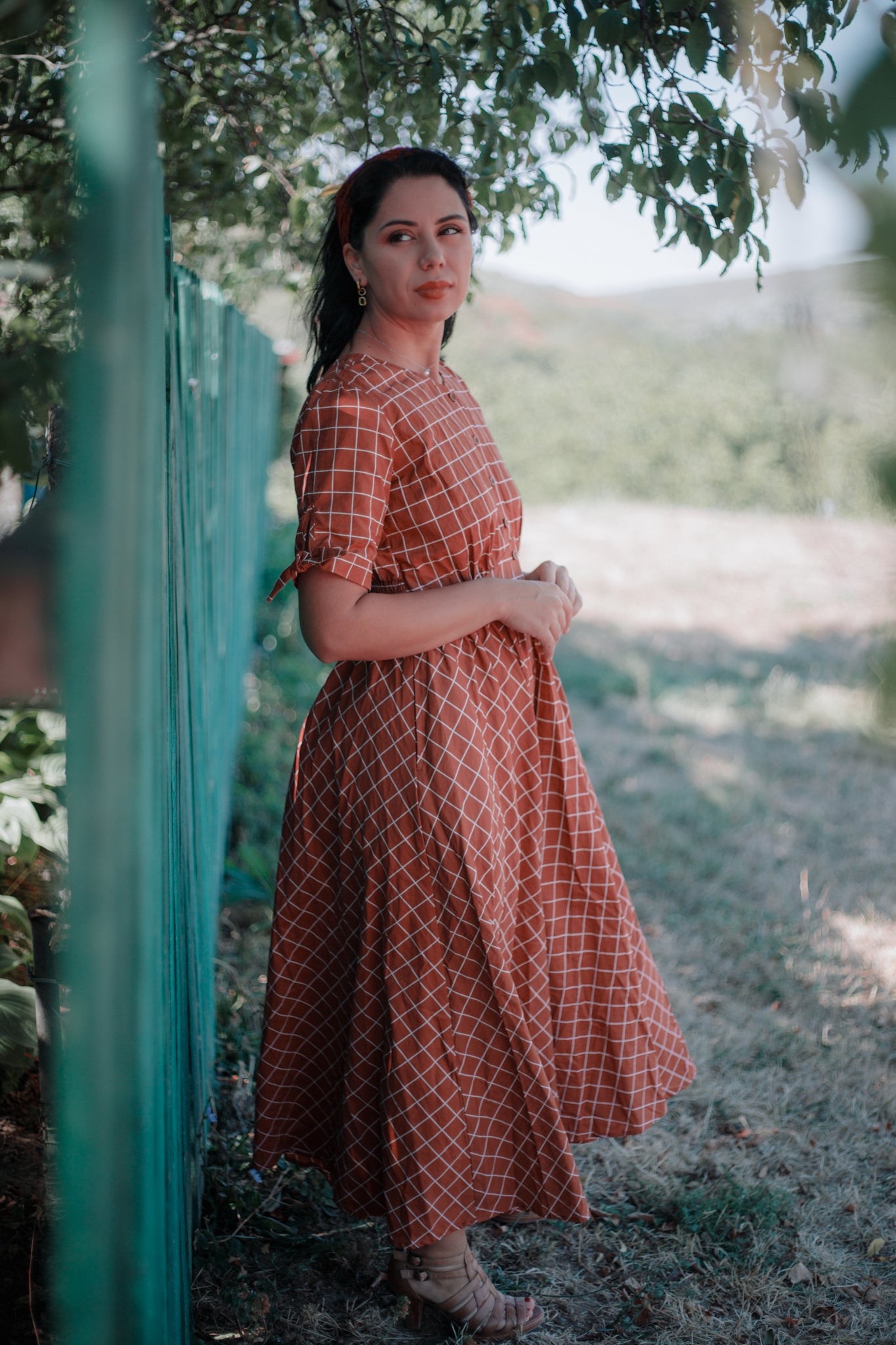 Woman in modest nursing checkered dress outdoors