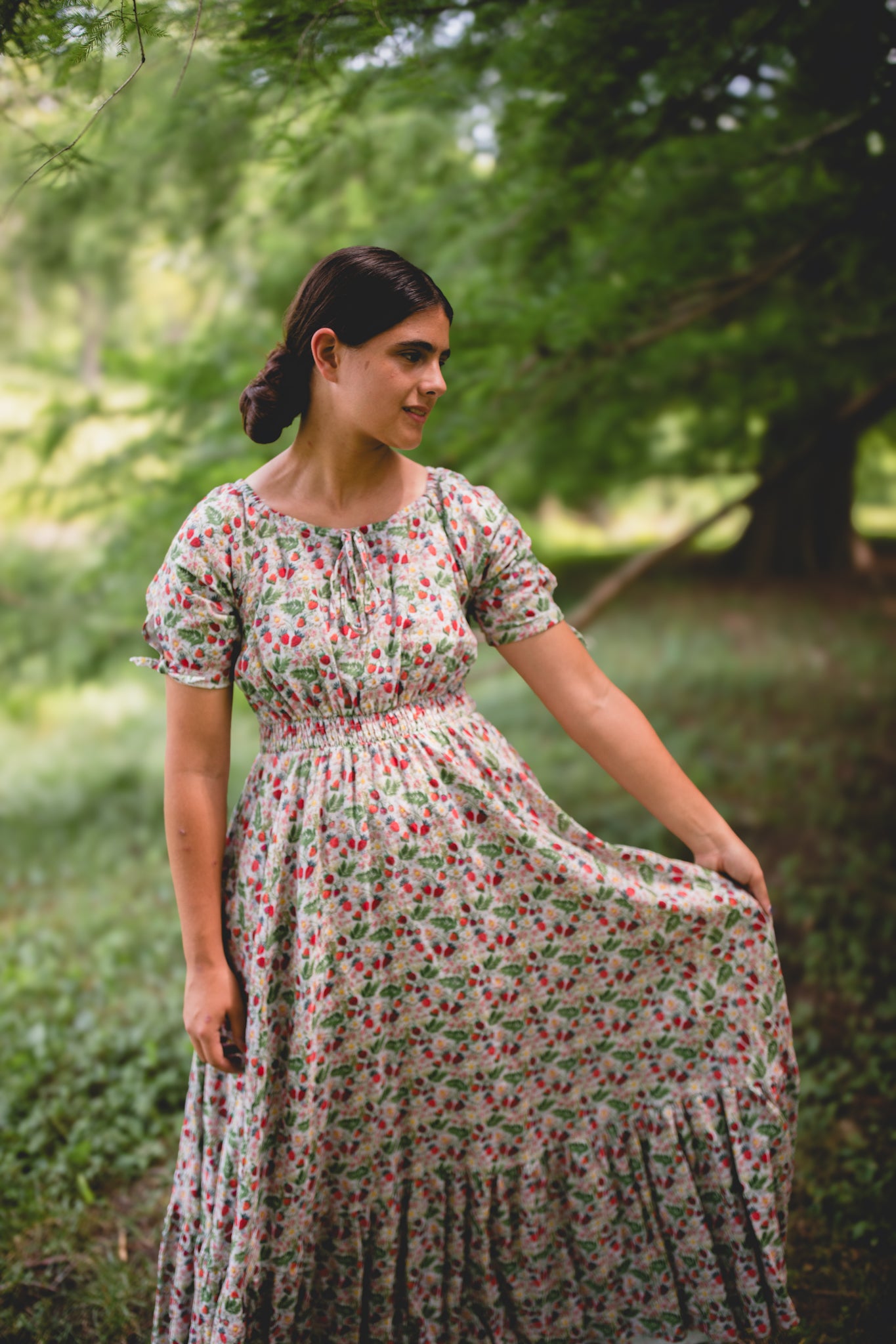 Woman in a floral modest nursing dress standing in a forest