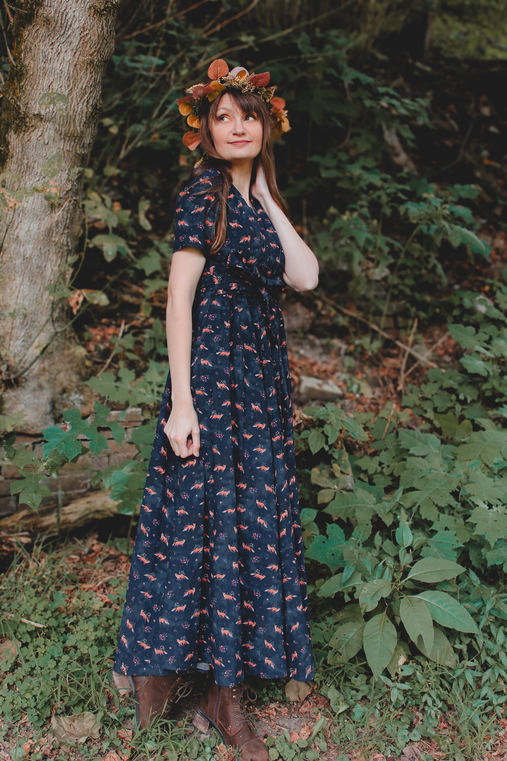 Woman in modest nursing dress, floral headband, forest