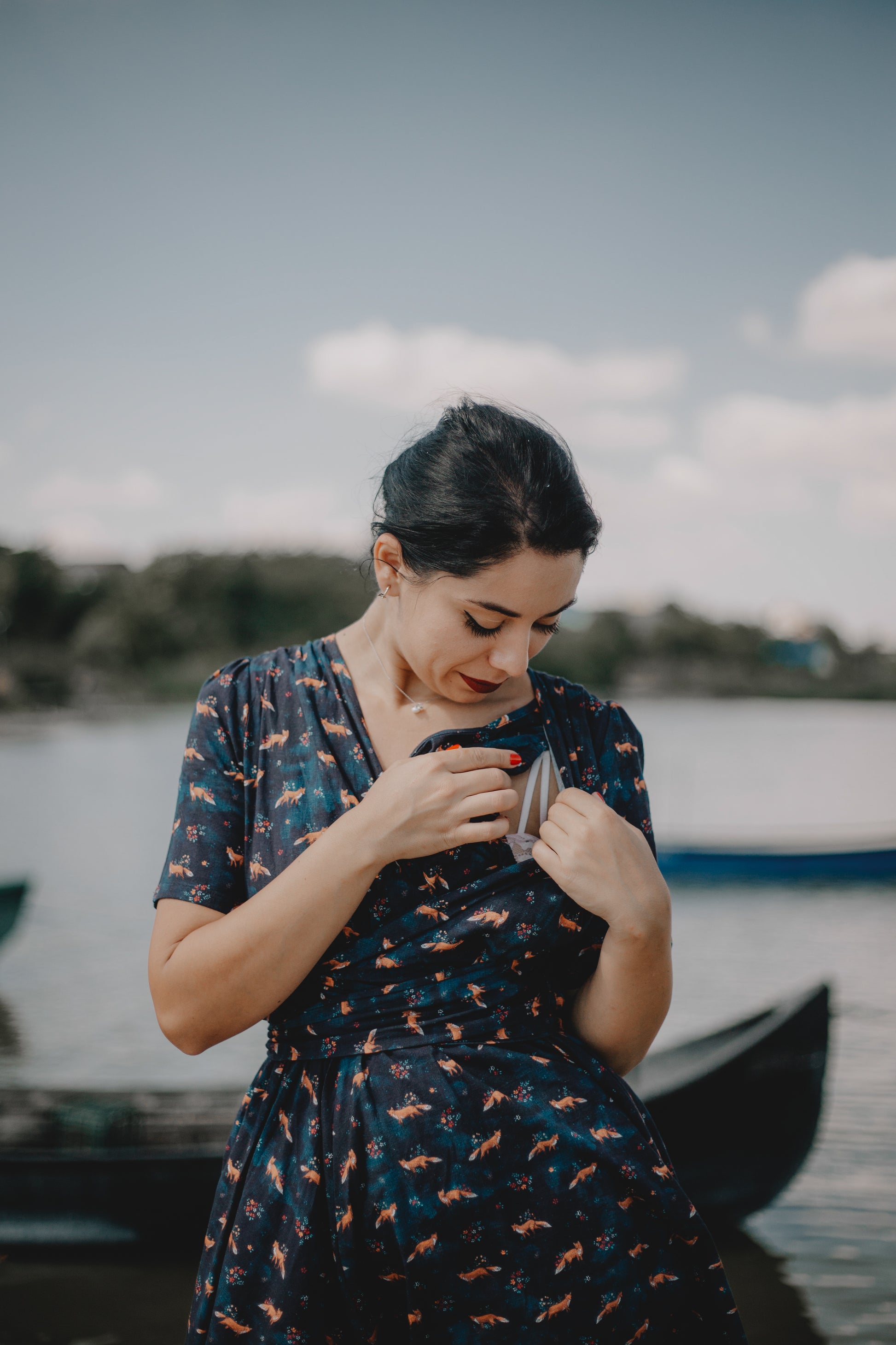 Woman in modest nursing dress by lake