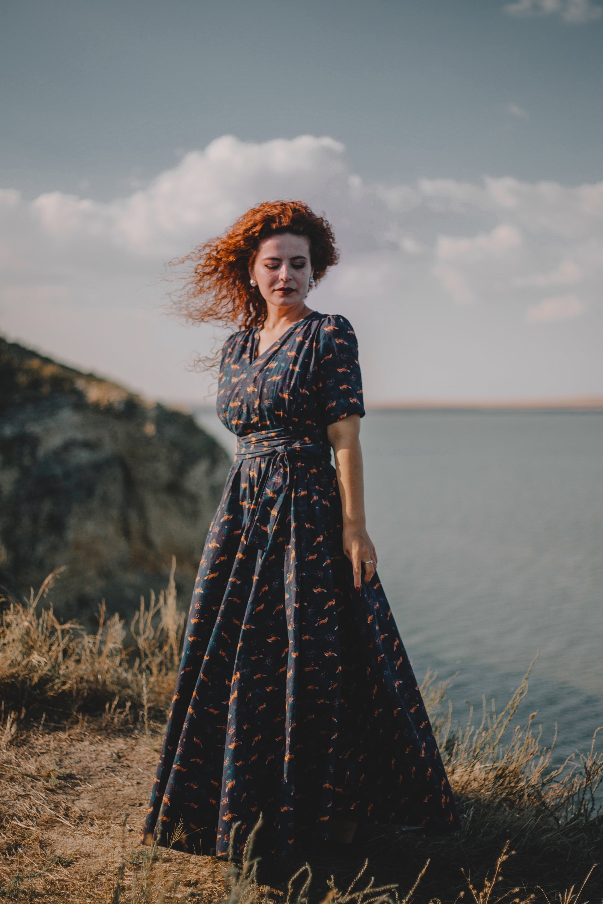 Woman in modest nursing dress on cliff
