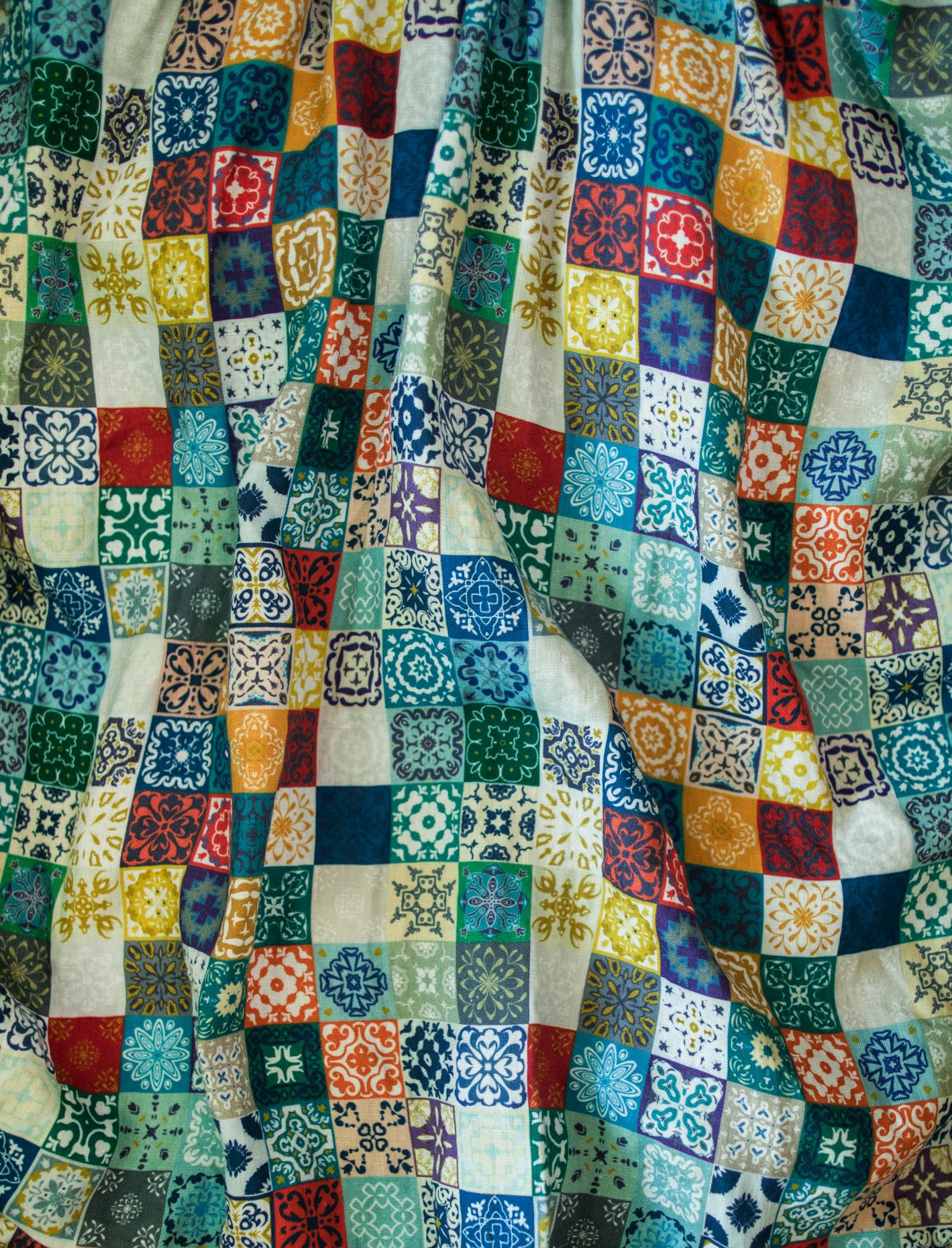 Multicolored fabric with square patterns in various colors.