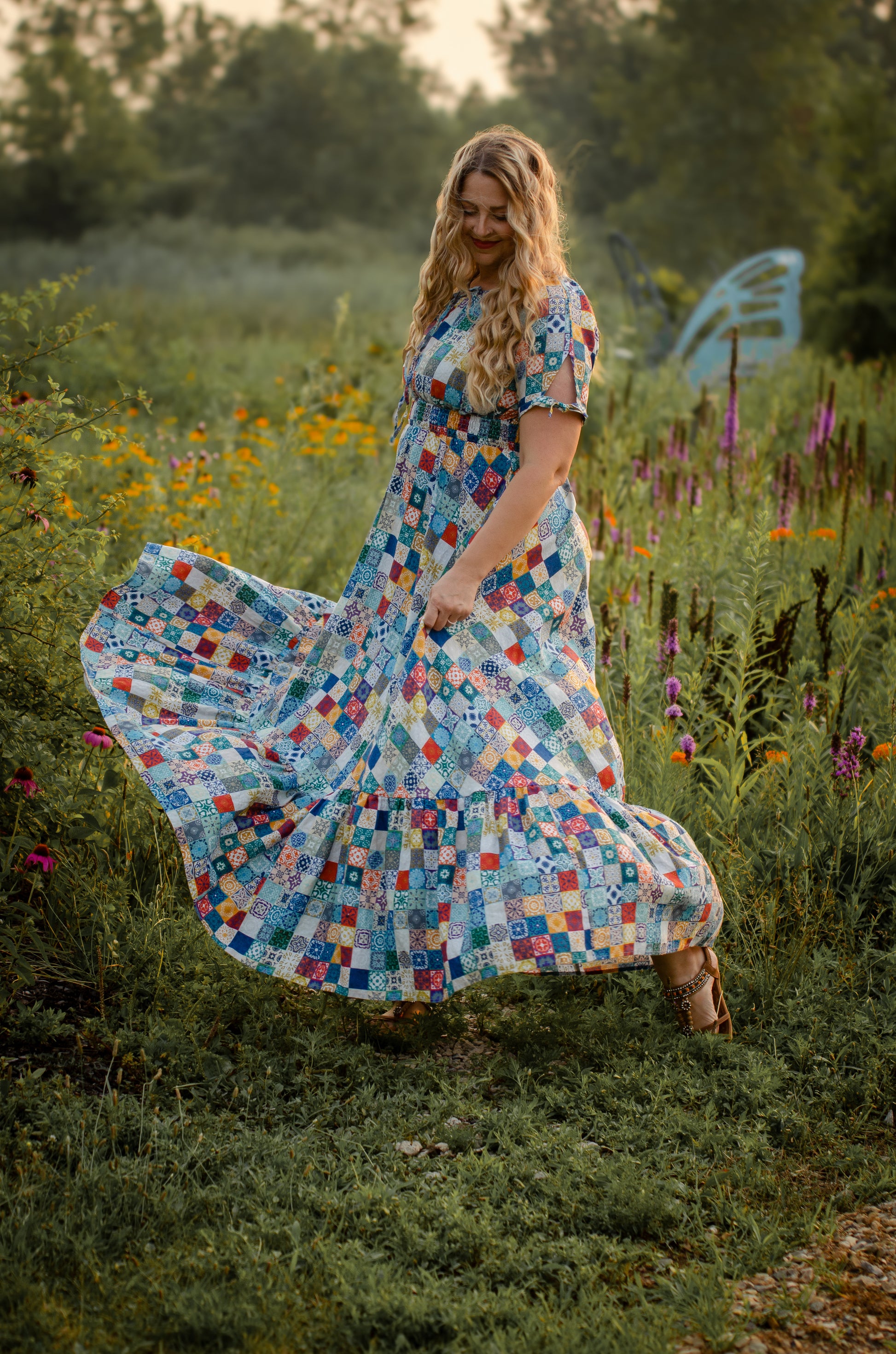 Woman in a colorful modest nursing dress standing in a field of flowers