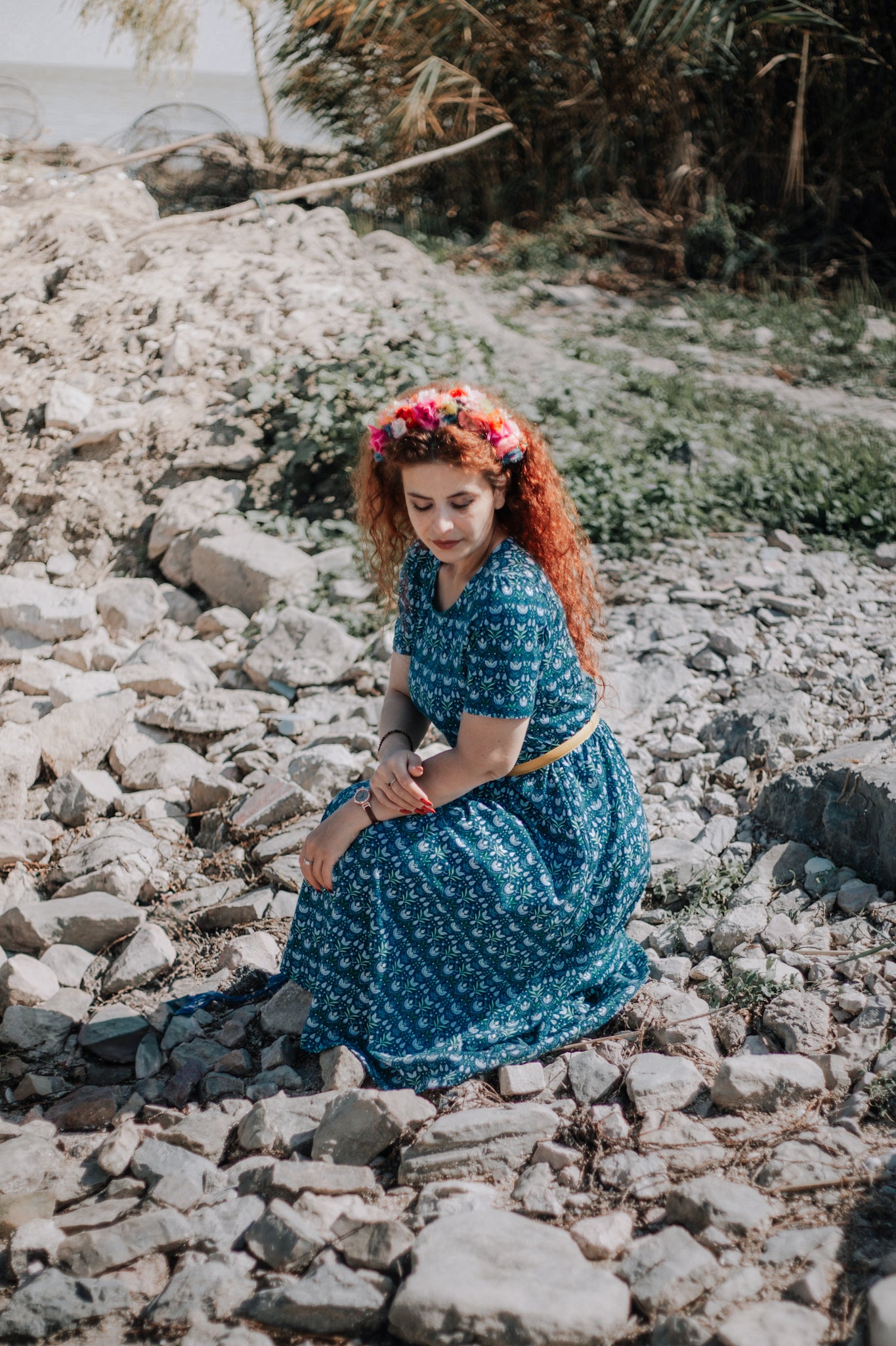 Woman in modest nursing dress by water.