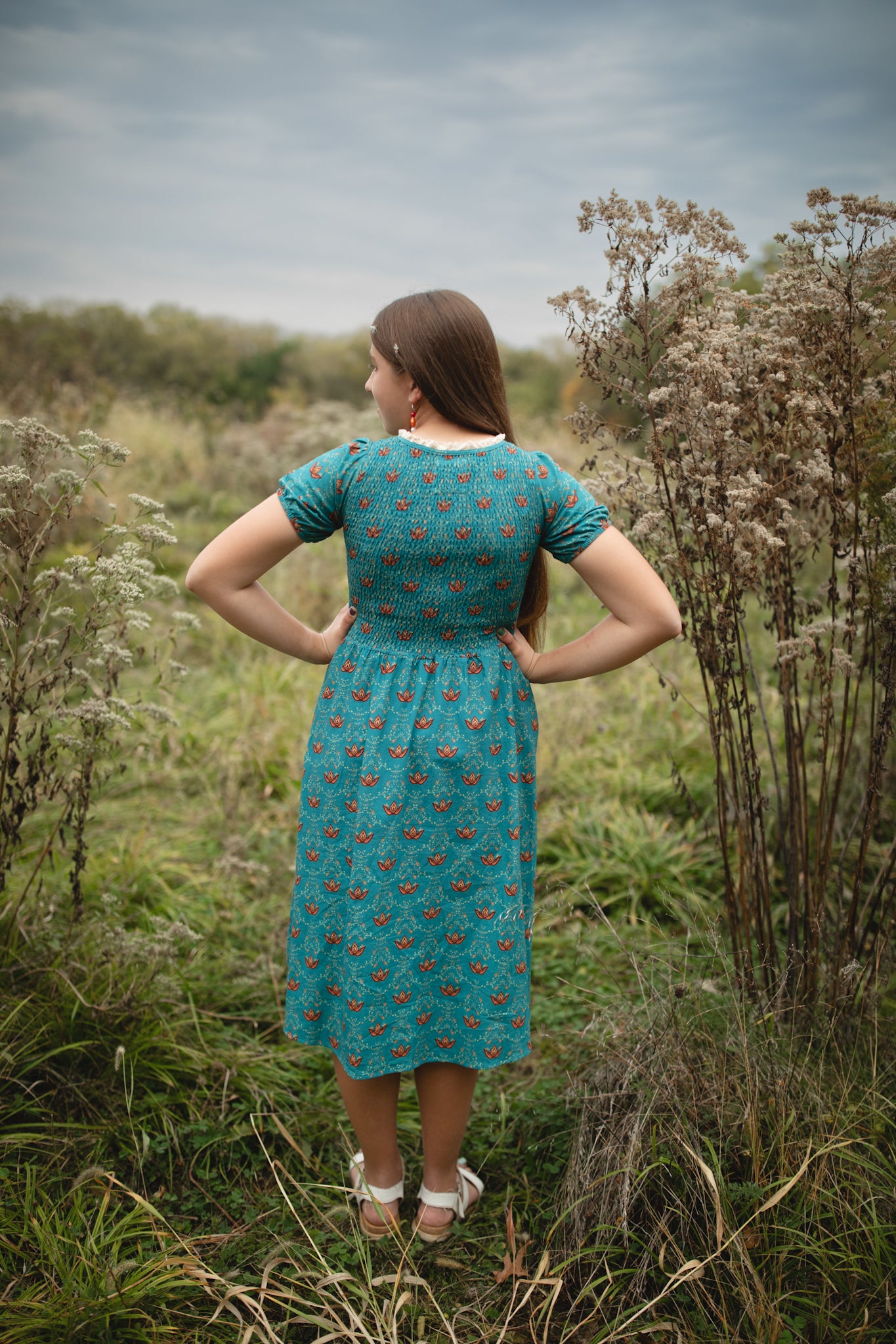 Woman wearing modest nursing dress in wildflower field.