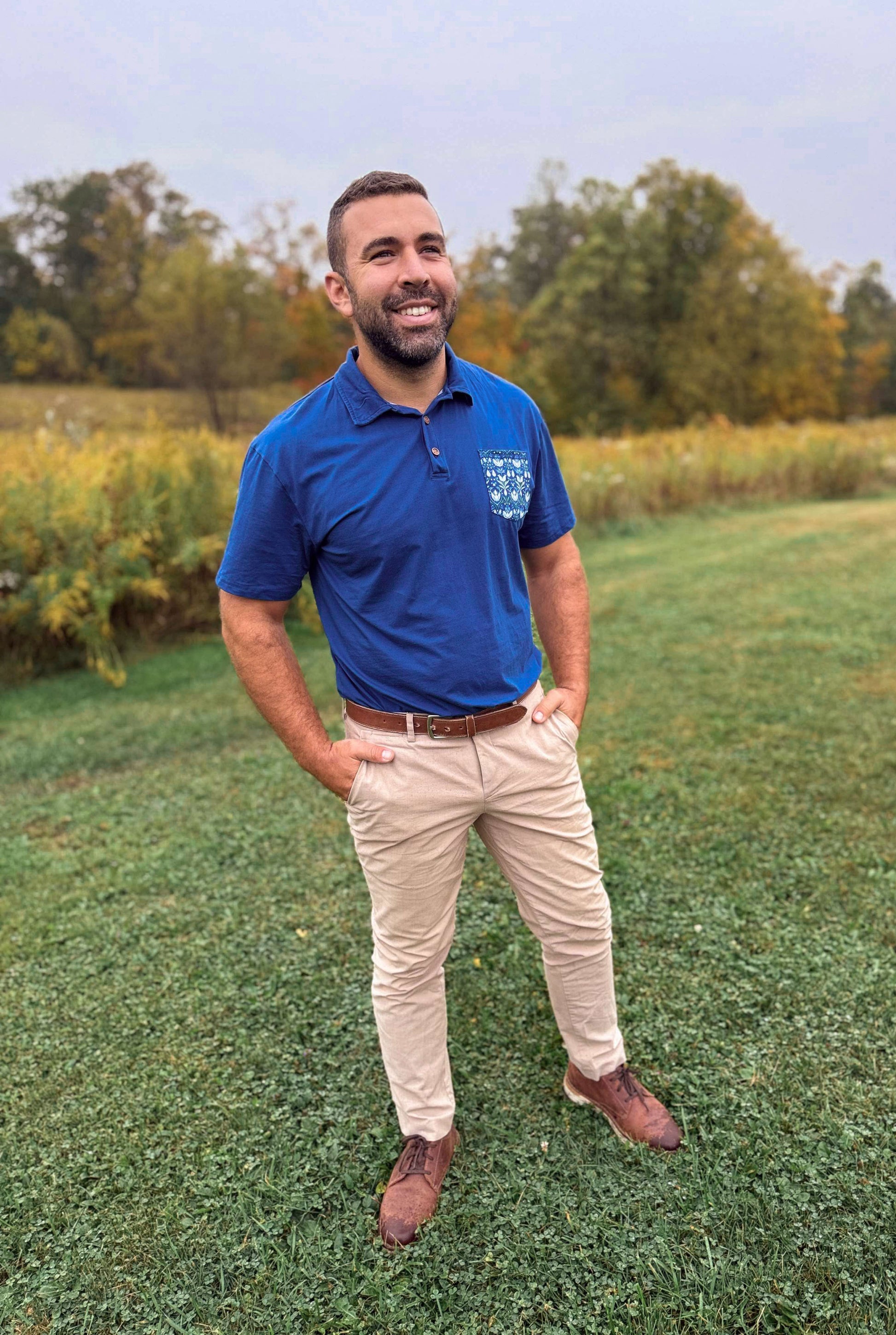 Man in blue polo in field.