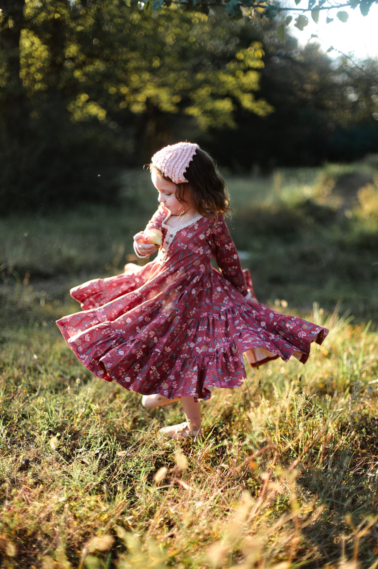 Young girl twirling in modest red floral dress