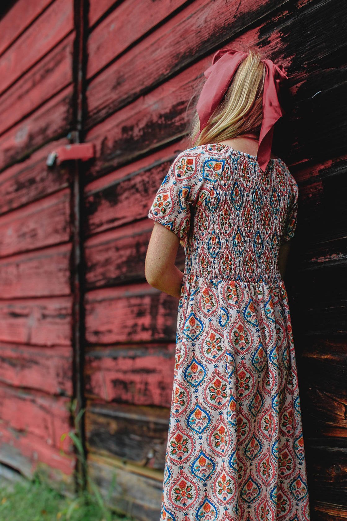 Woman in modest nursing dress against red wall