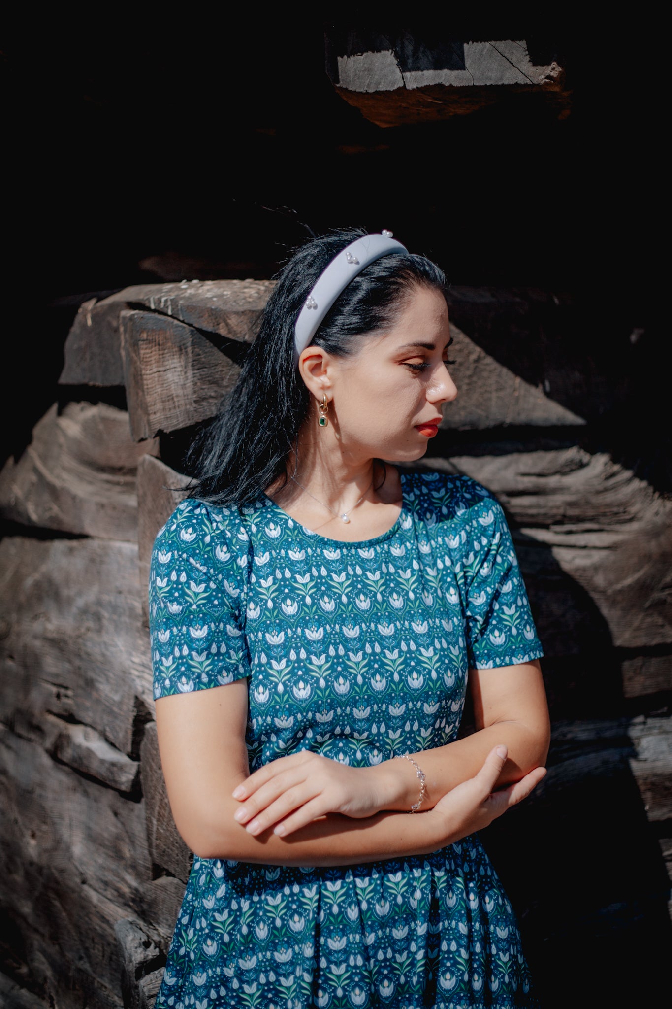 Woman in modest nursing dress, dark background.