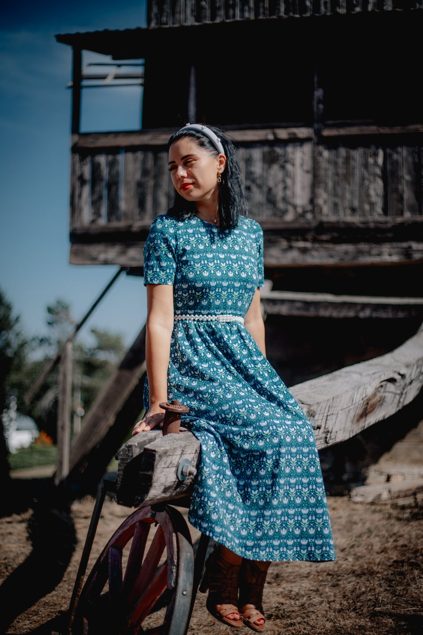 Woman in modest nursing dress, wooden structure.