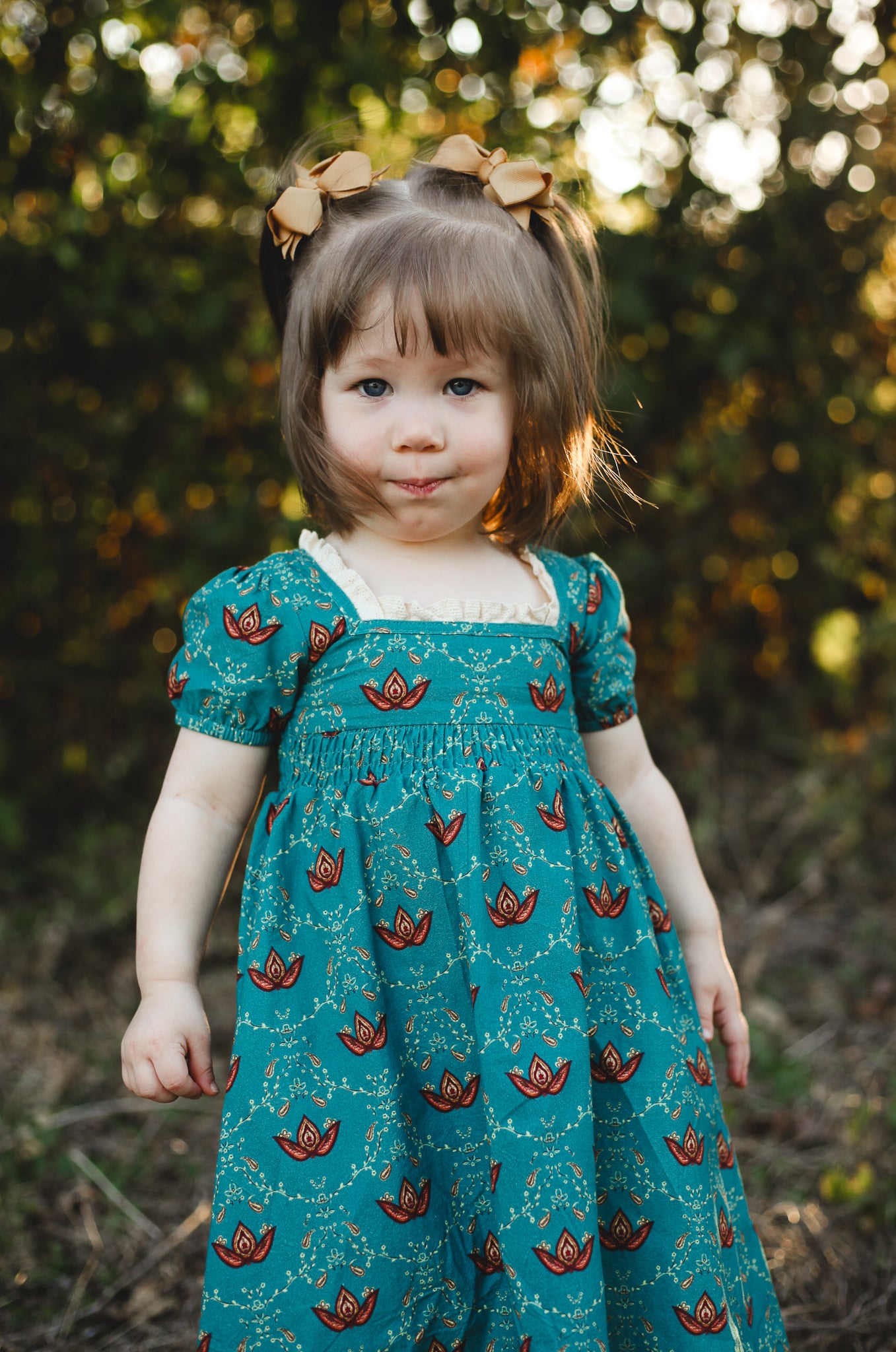 Young girl in modest dress with floral pattern.