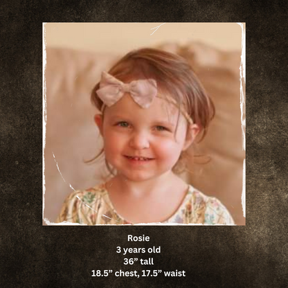 Young girl wearing modest dress with bow smiling