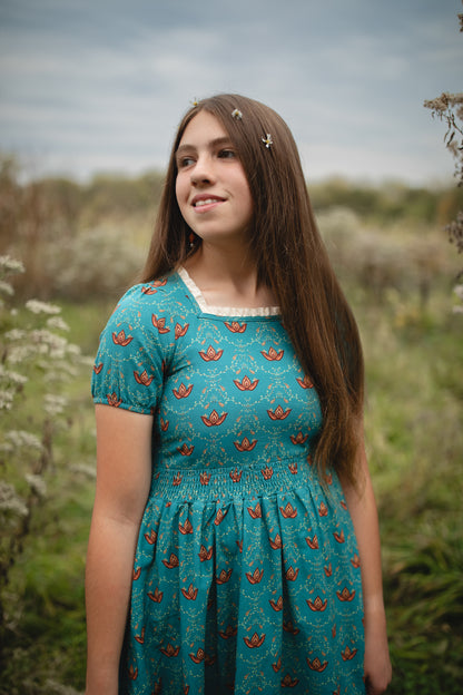Young woman wearing modest nursing dress with patterns.