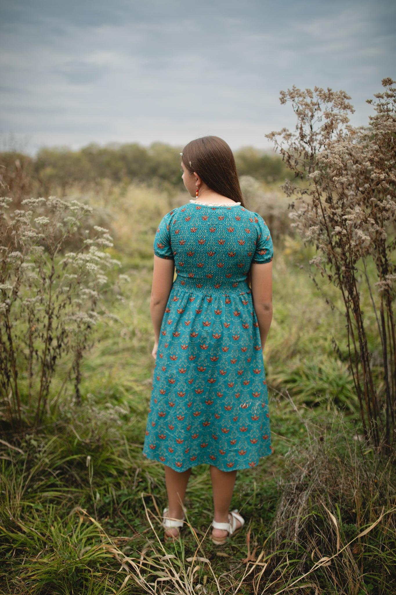 Woman wearing modest nursing dress outdoors in field