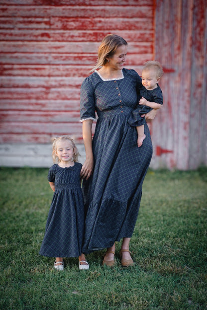 woman wearing a modest nursing blue patterned dress with her daughters wearing matching dresses