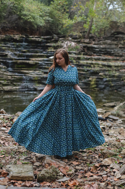 Woman in modest nursing dress by stream