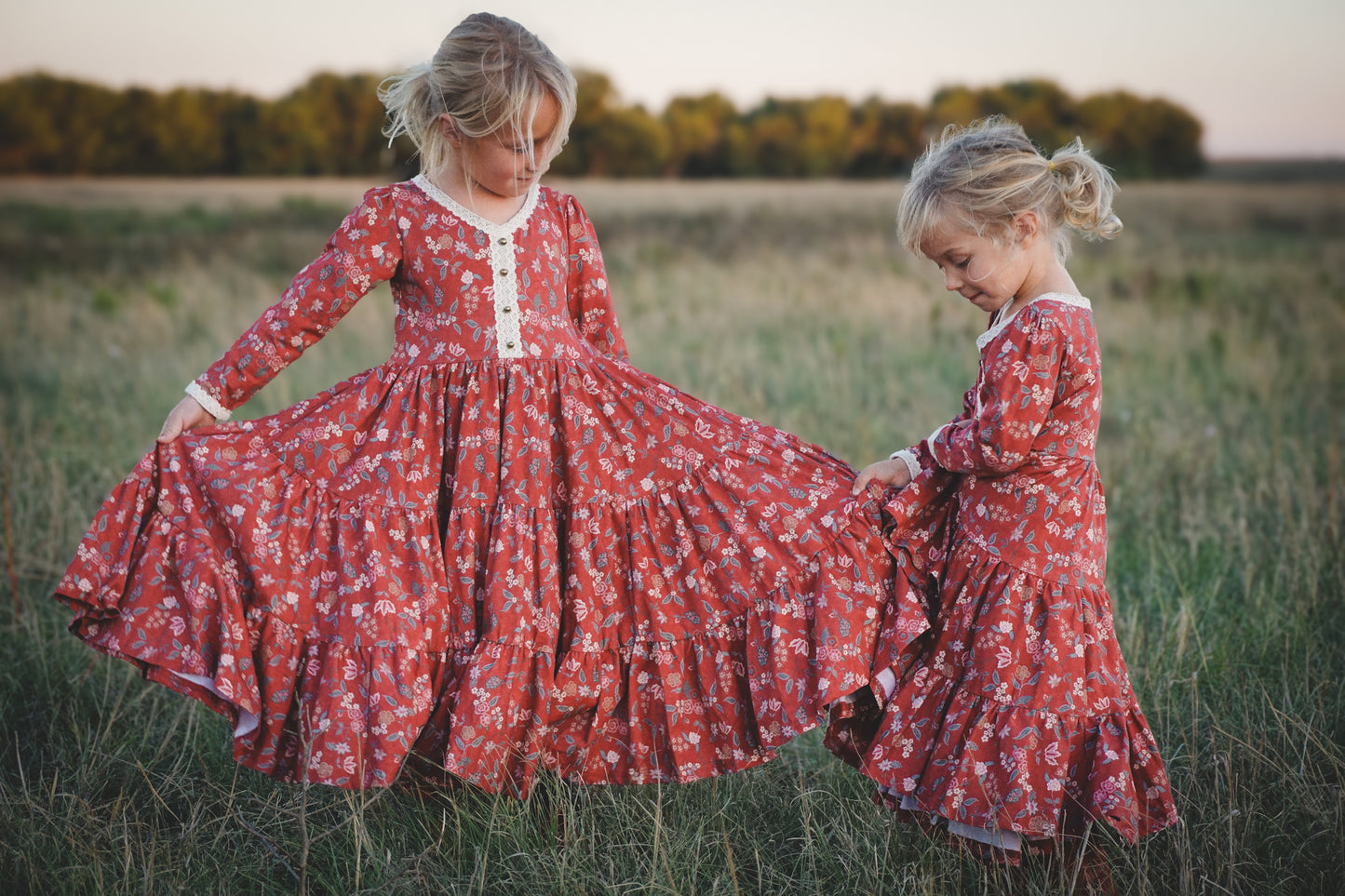 Two young girls in modest red floral dresses