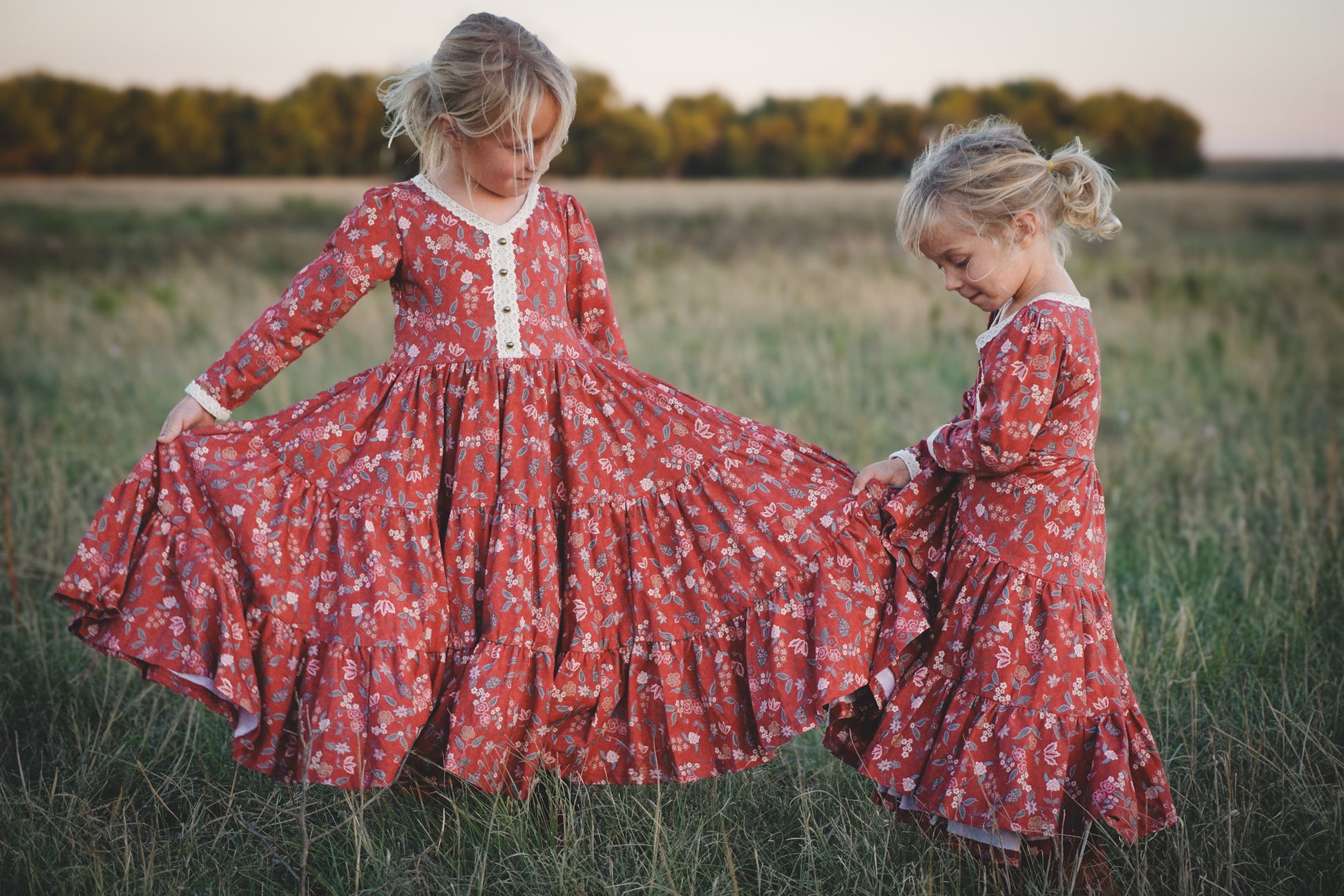 Two young girls in modest red floral dresses