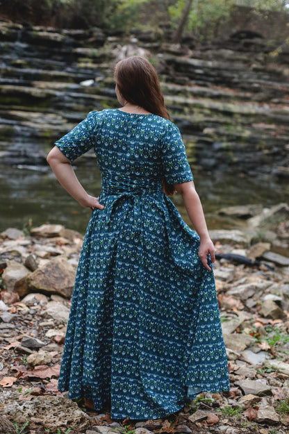 Woman in modest nursing dress by stream