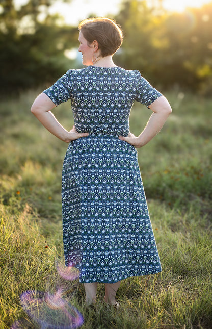 Woman in modest nursing dress, field with sunlight.