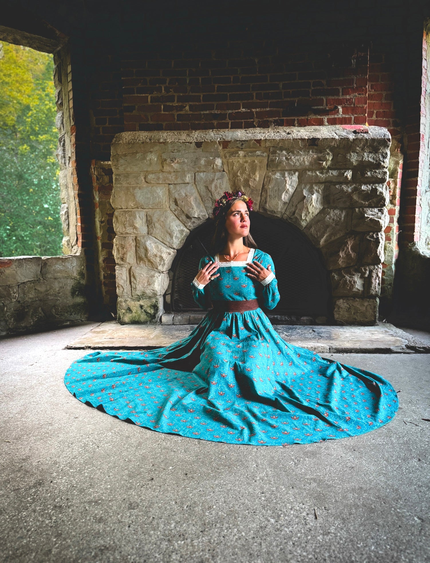 Woman in modest nursing blue dress by fireplace