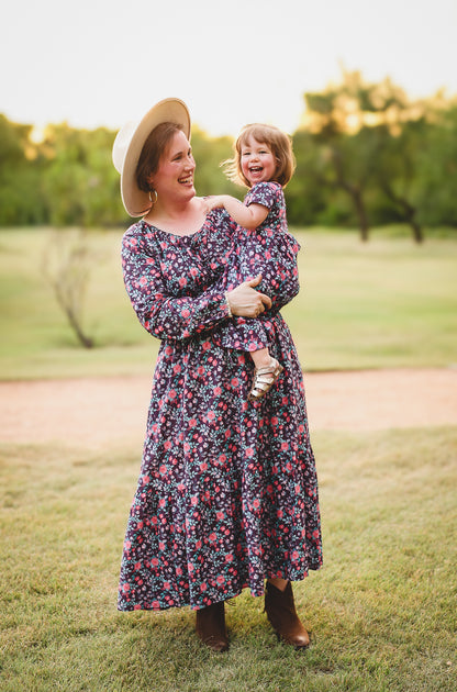 Woman in modest nursing dress holding child