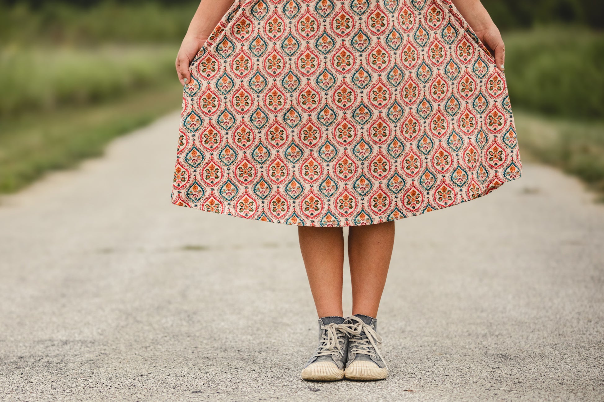 Young girl in modest patterned dress on road