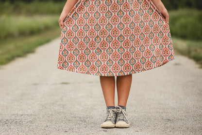 Young girl in modest patterned dress on road