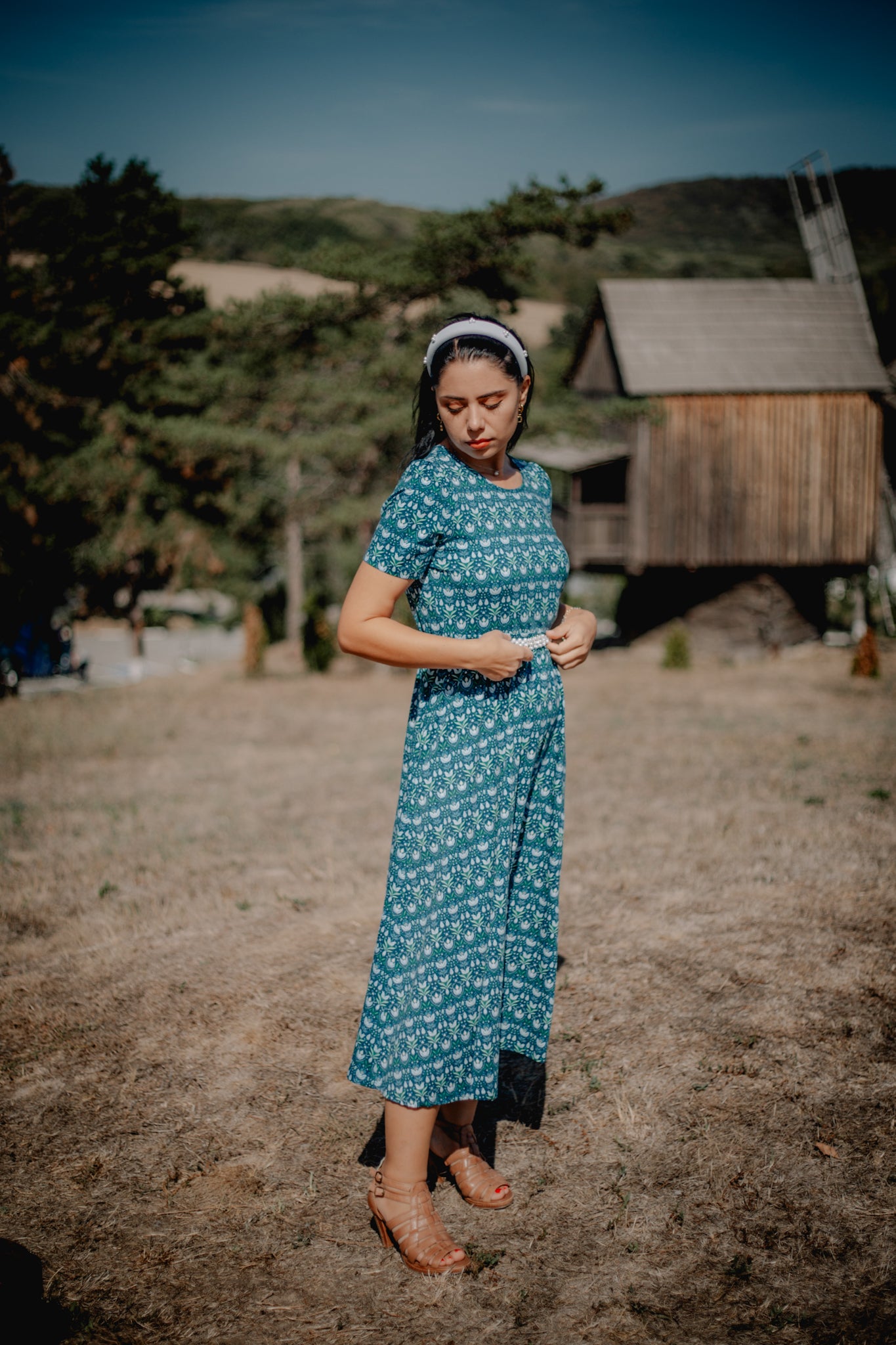 Woman in modest nursing dress near wooden structure