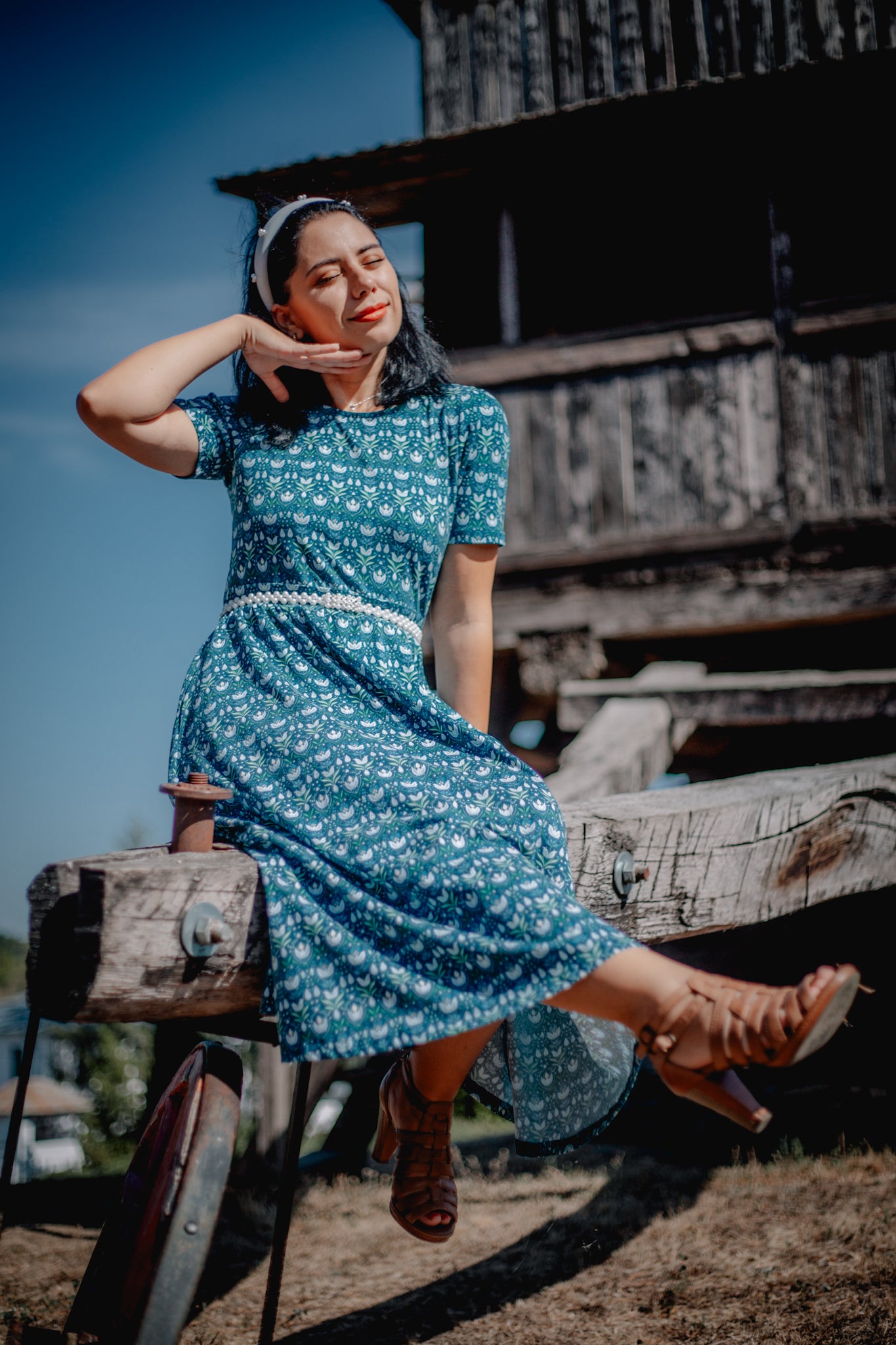 Woman in modest nursing dress, bench outdoors.