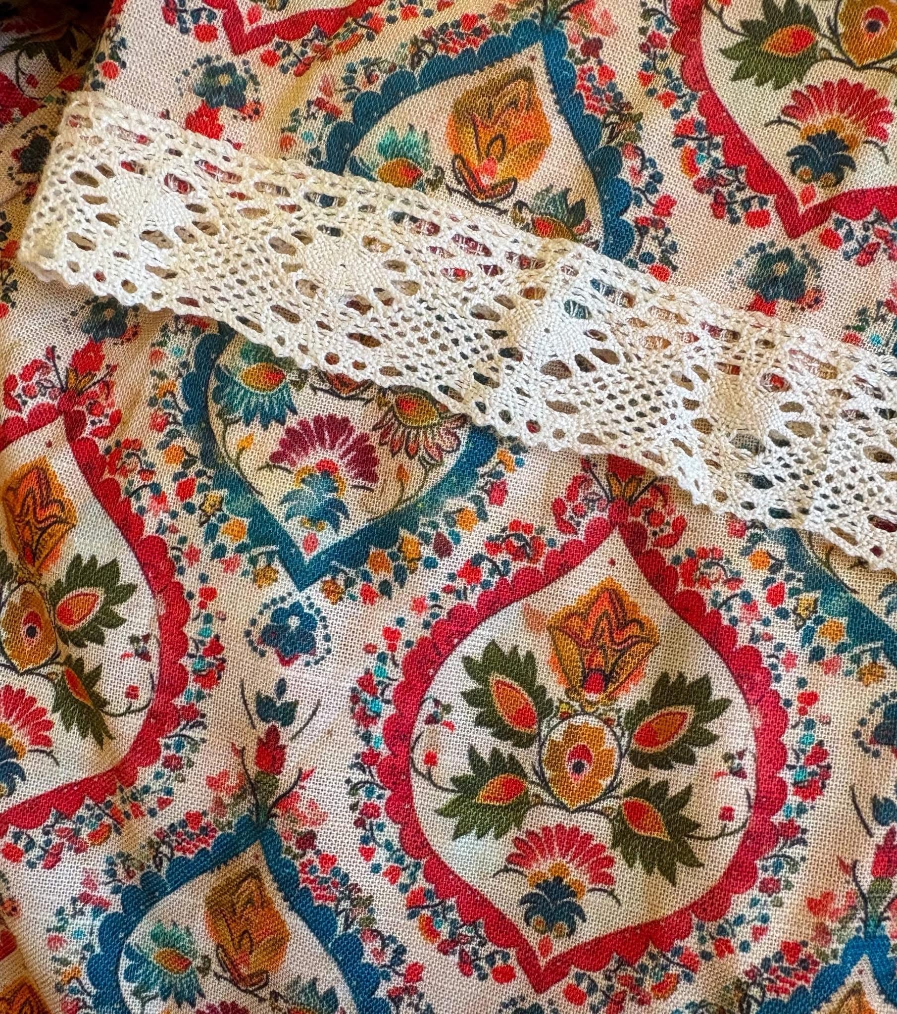 Decorative fabric with intricate patterns and a lace trim