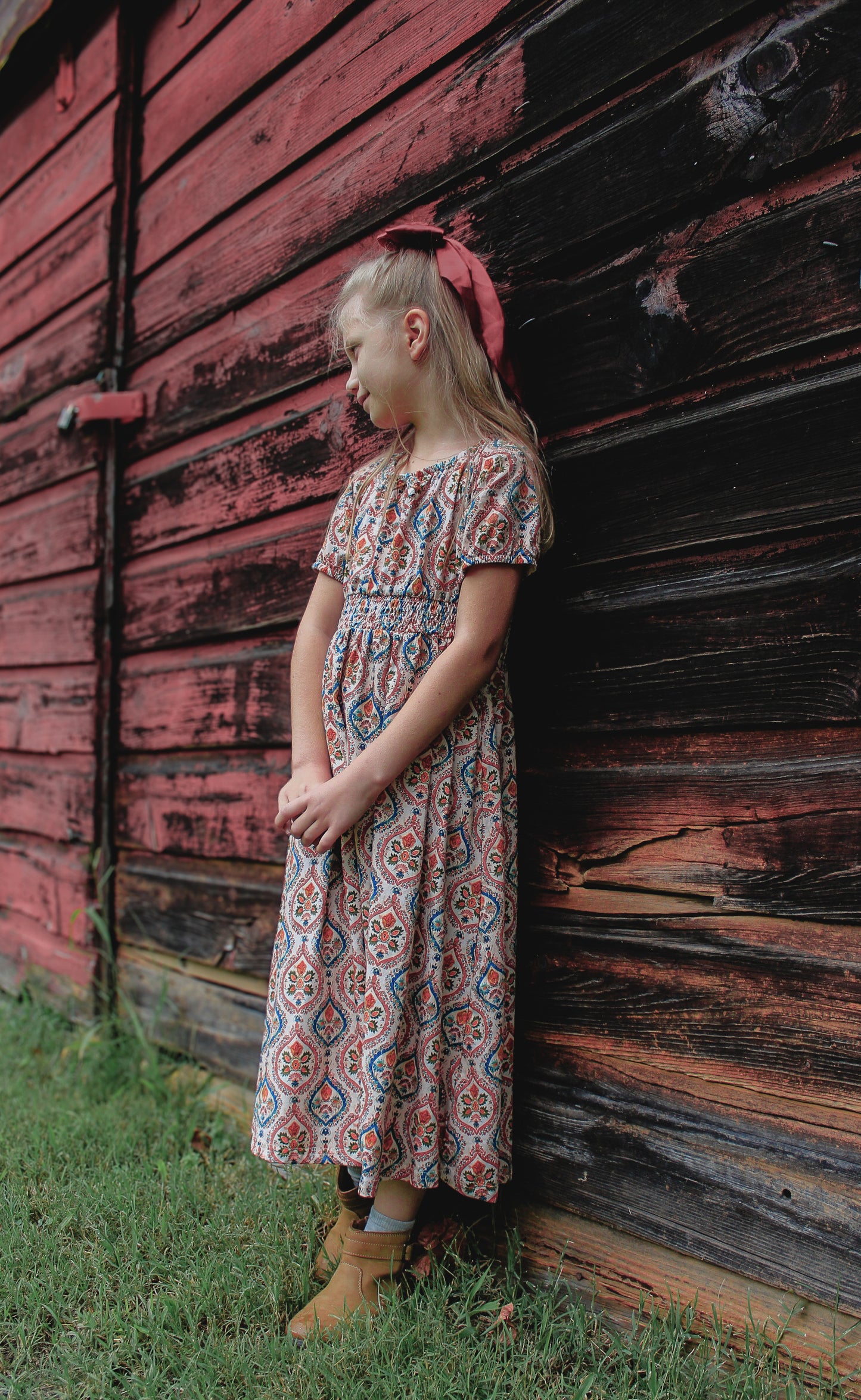 Young girl wearing modest patterned folklore dress outdoors