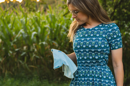 Woman in modest nursing dress holding cloth in field