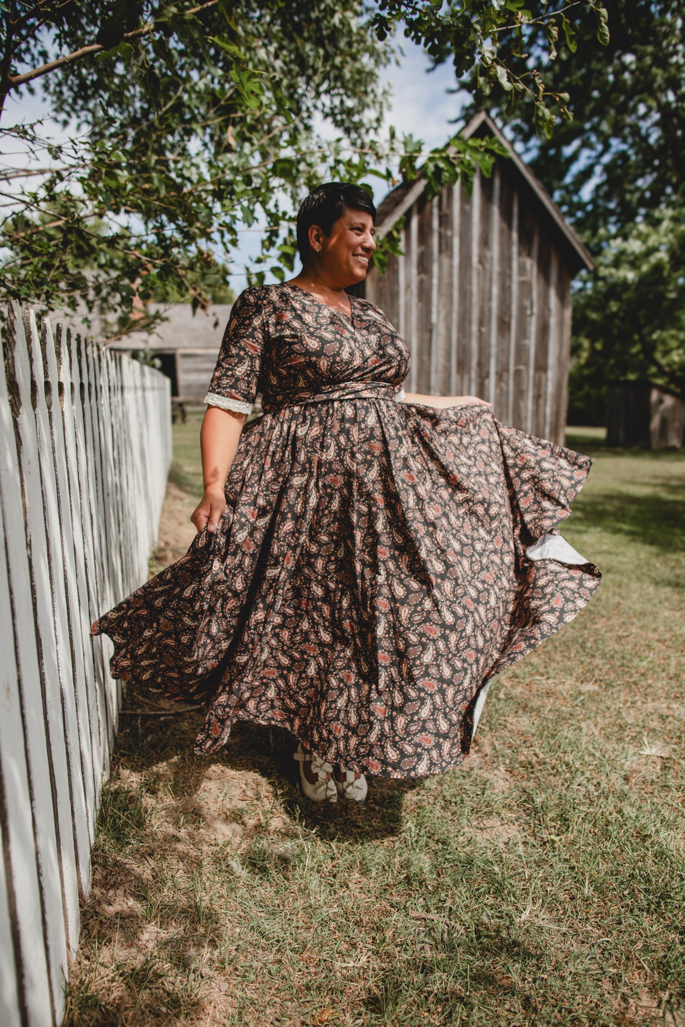 Woman in modest nursing dress outdoors near fence