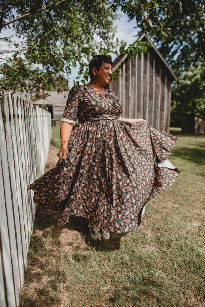 Woman in modest nursing dress outdoors near fence