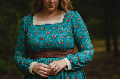 Woman in modest nursing blue dress holding lantern