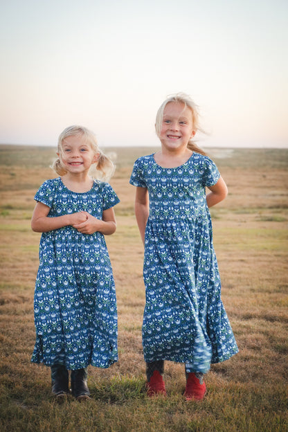 Two girls in modest nursing dresses outdoors at sunset