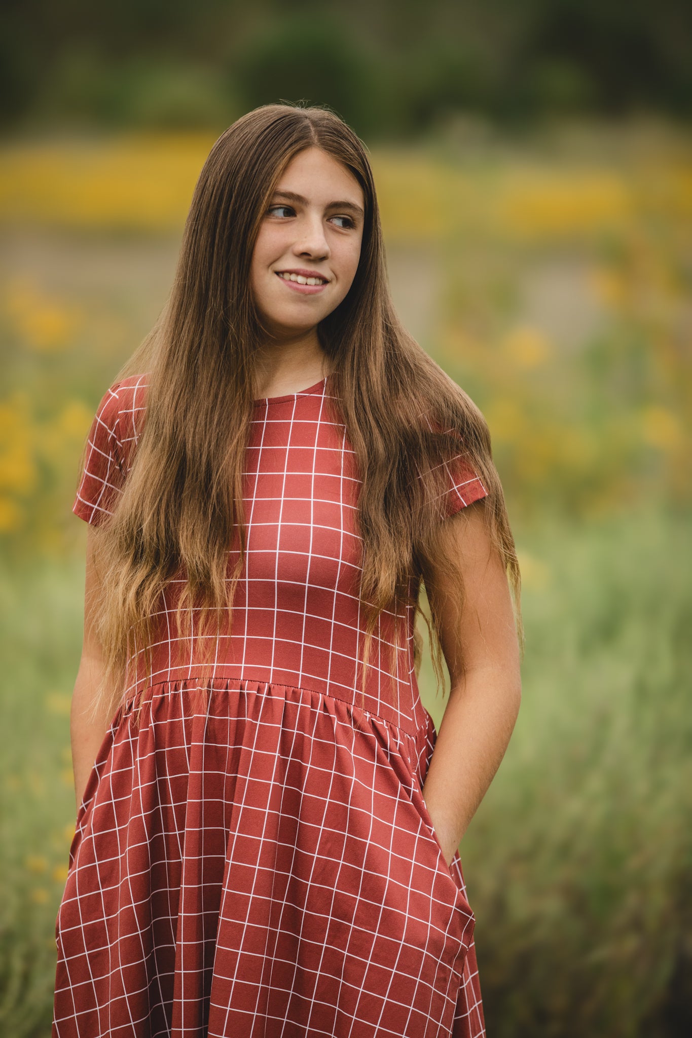 Woman in modest checkered dress, nursing-friendly design.