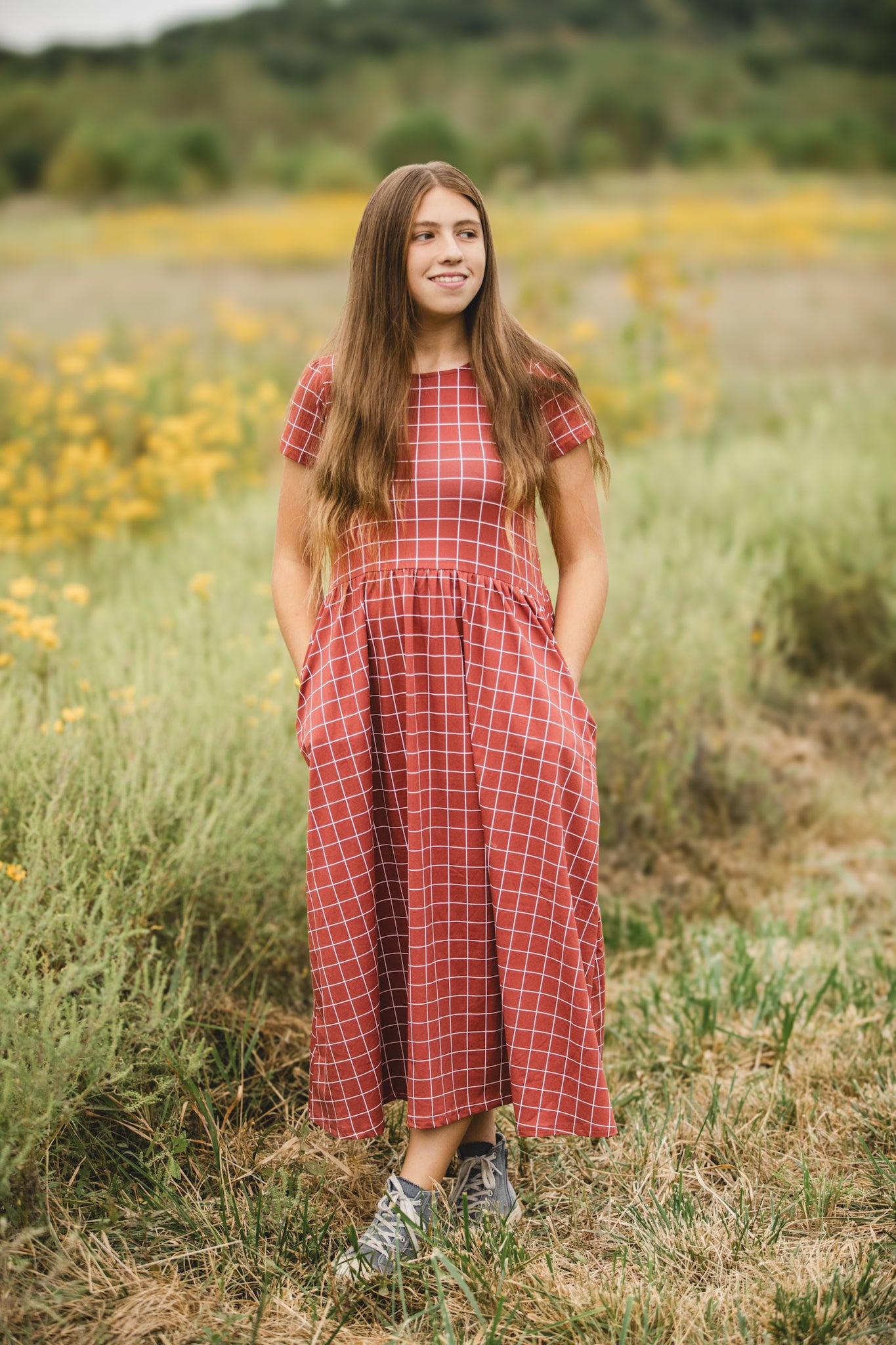 Woman in modest checkered dress, nursing-friendly design.