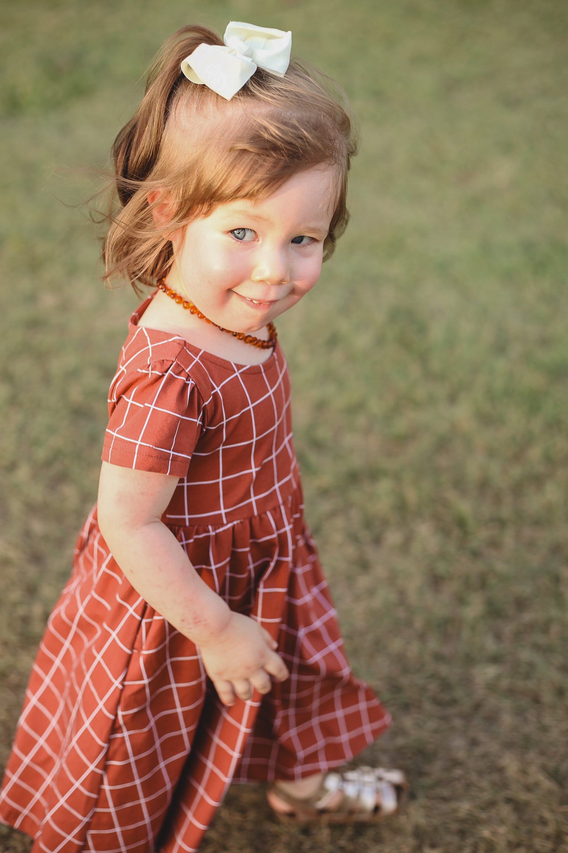 Girl in modest checkered dress, ready for nursing.