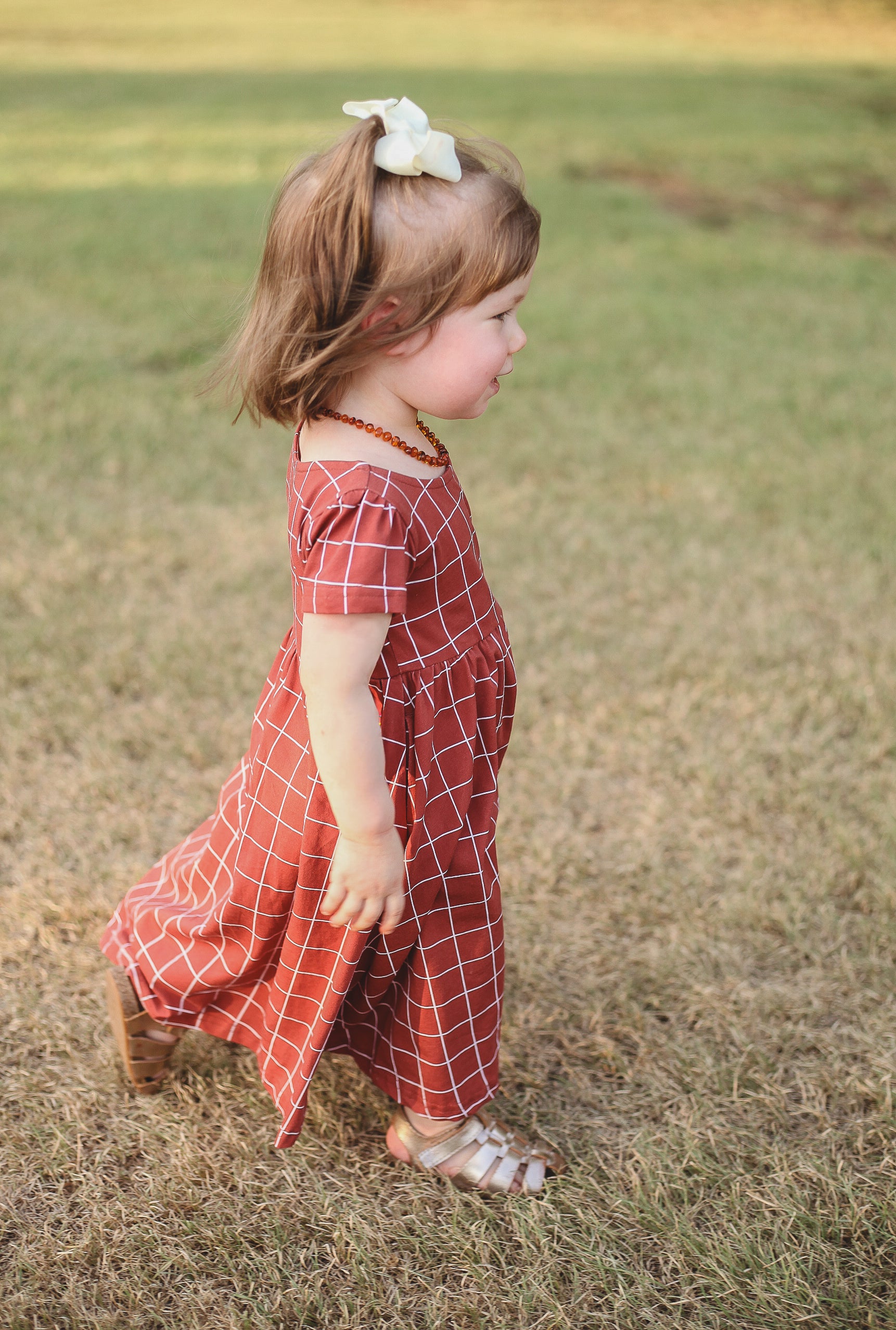 Girl in modest checkered dress, ready for nursing.