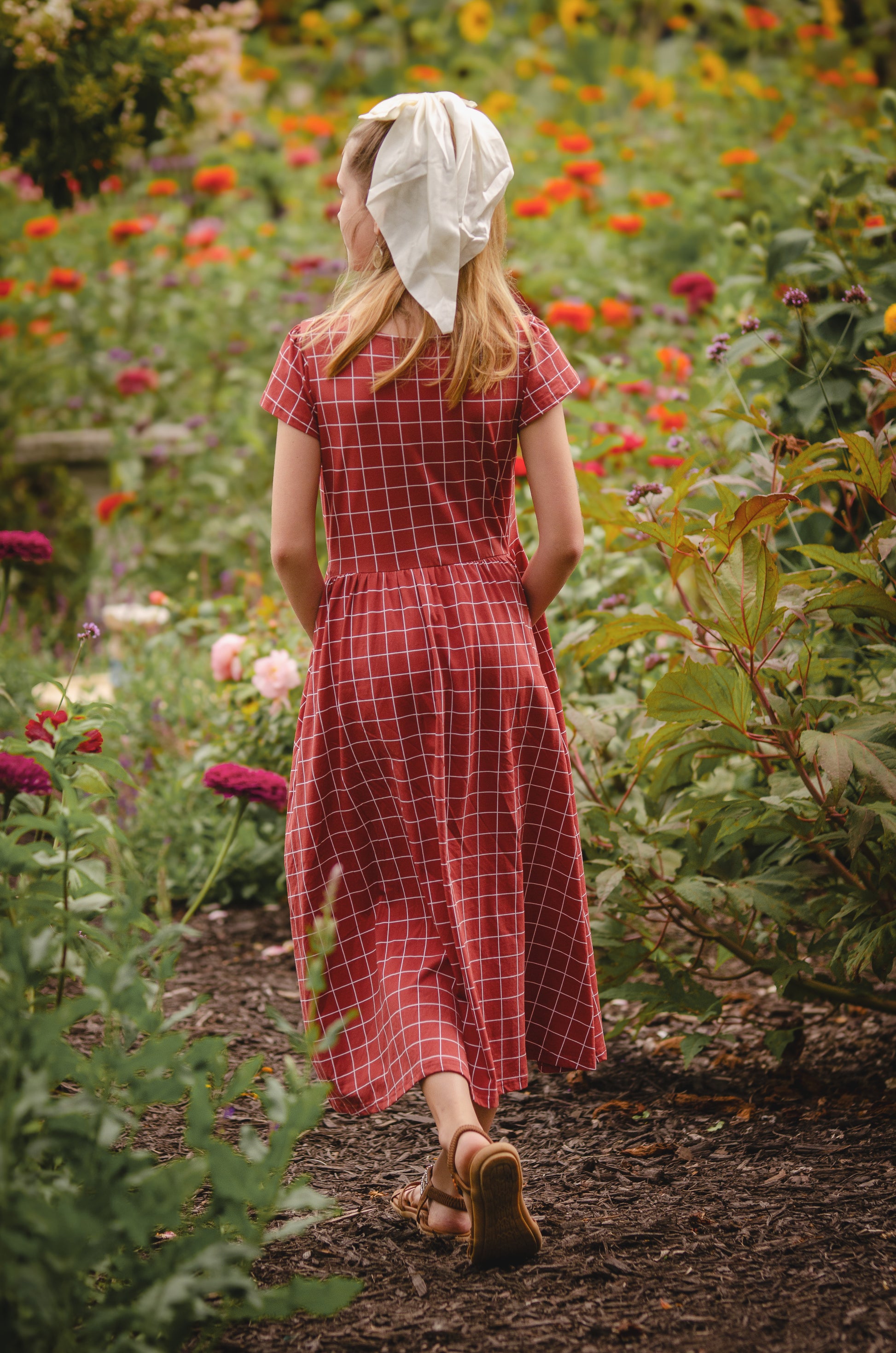 Woman in modest checkered dress, nursing-friendly design.