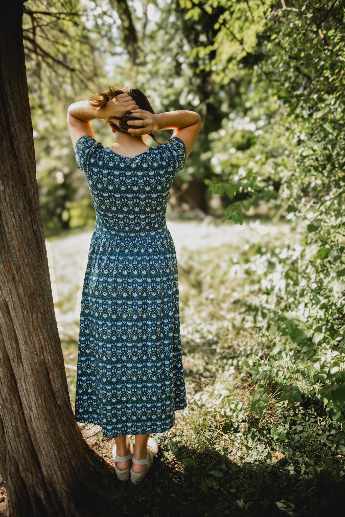 Woman in modest nursing dress standing in garden