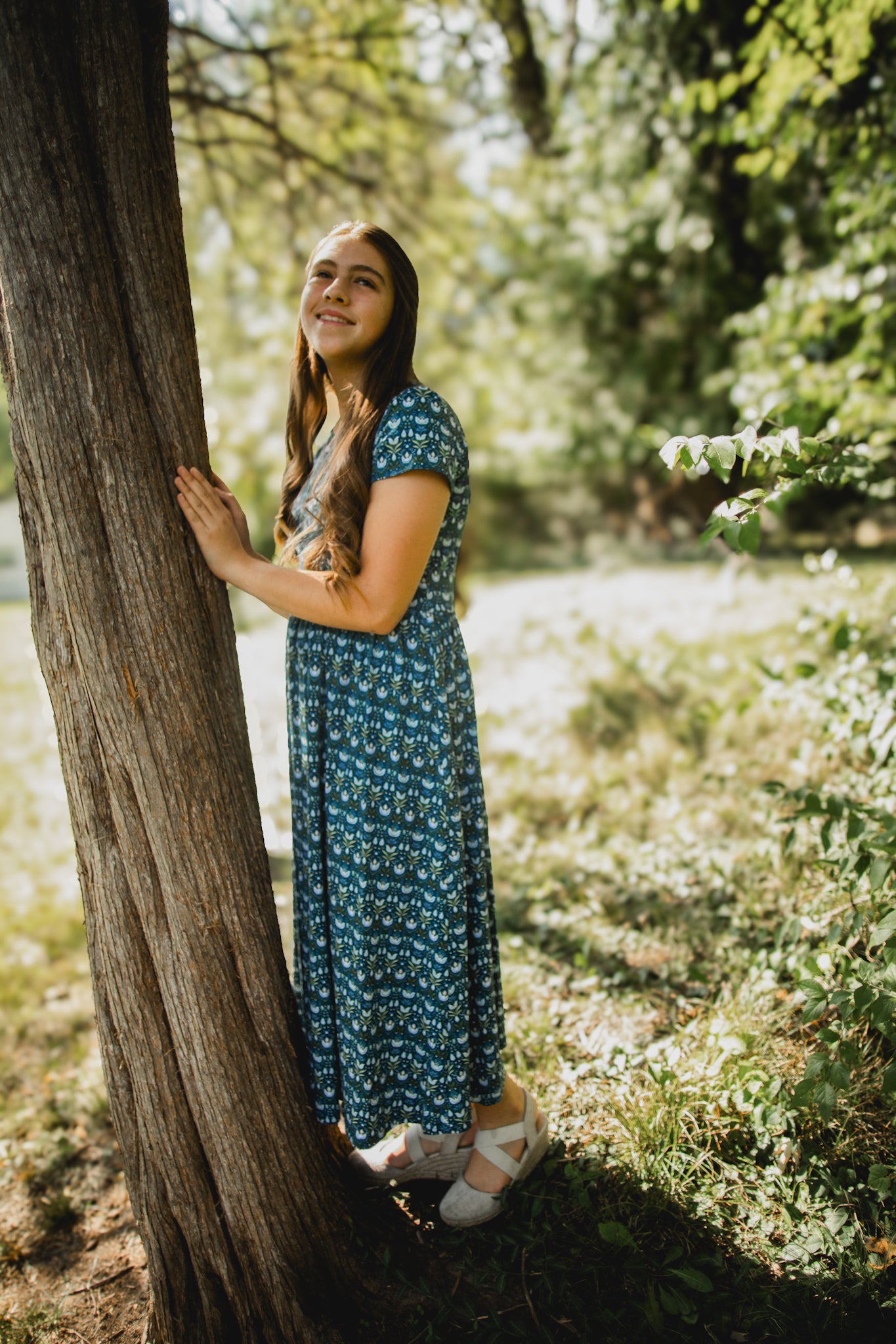 Woman in modest nursing dress near tree outdoors