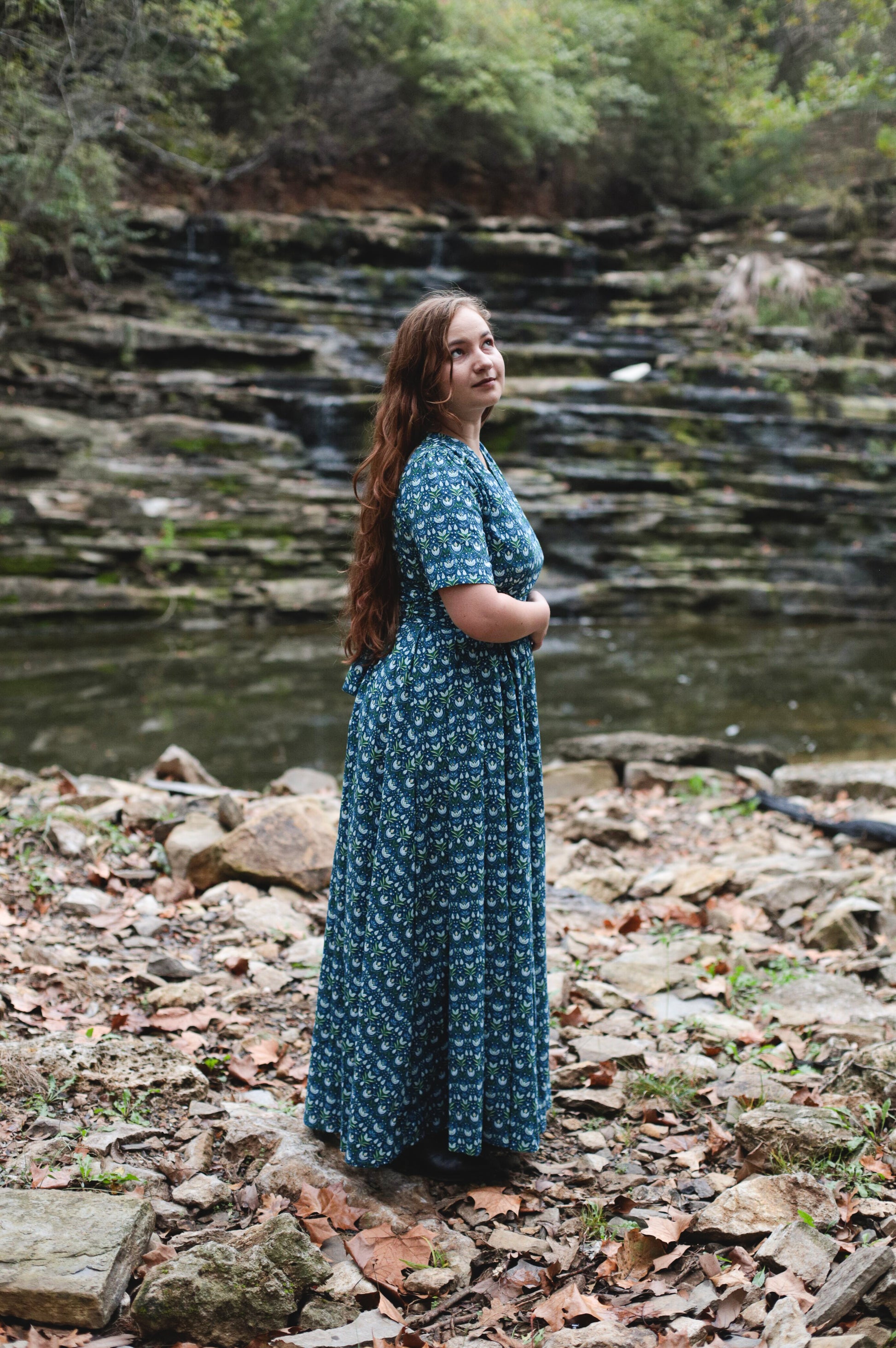 Woman in modest nursing dress by stream