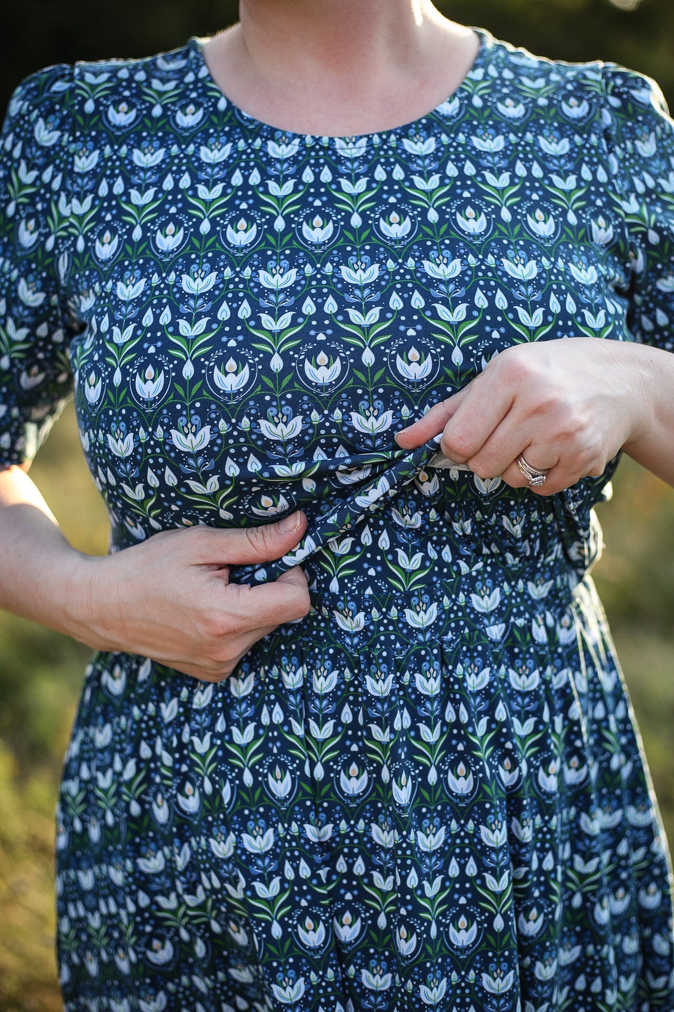 Woman in modest nursing dress, natural background.