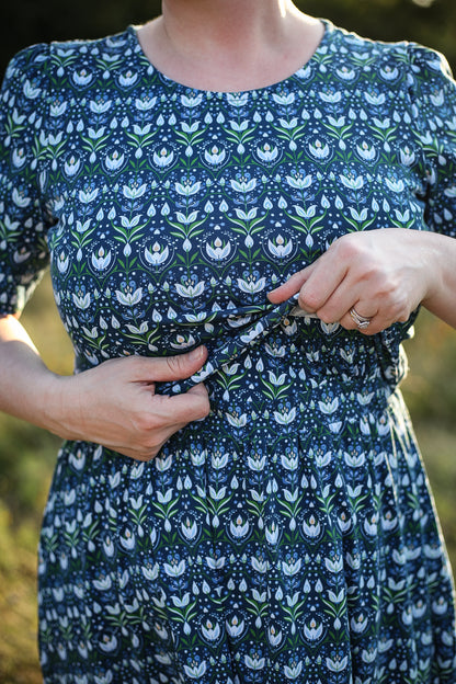 Woman in modest nursing dress, natural background.