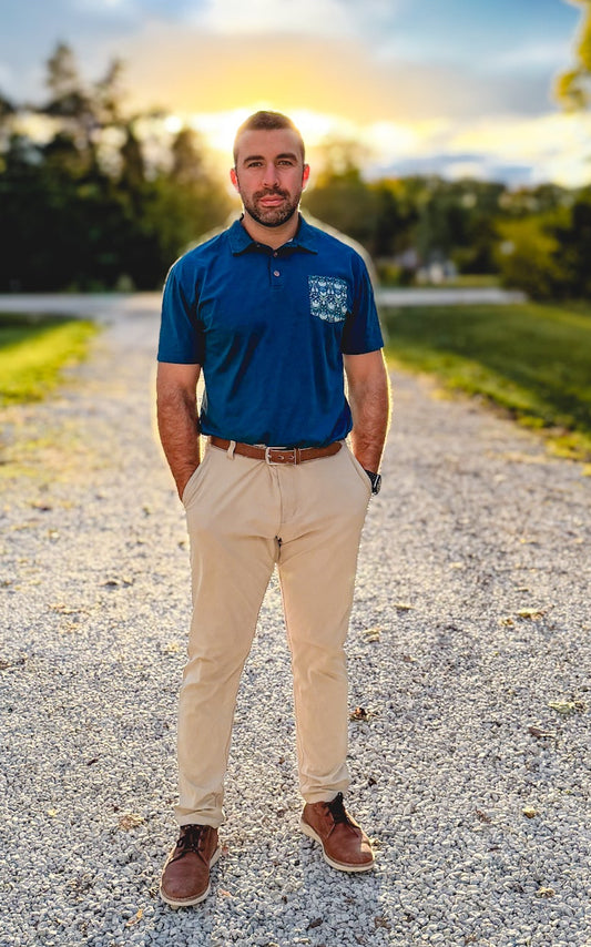 Man in blue polo on gravel road.