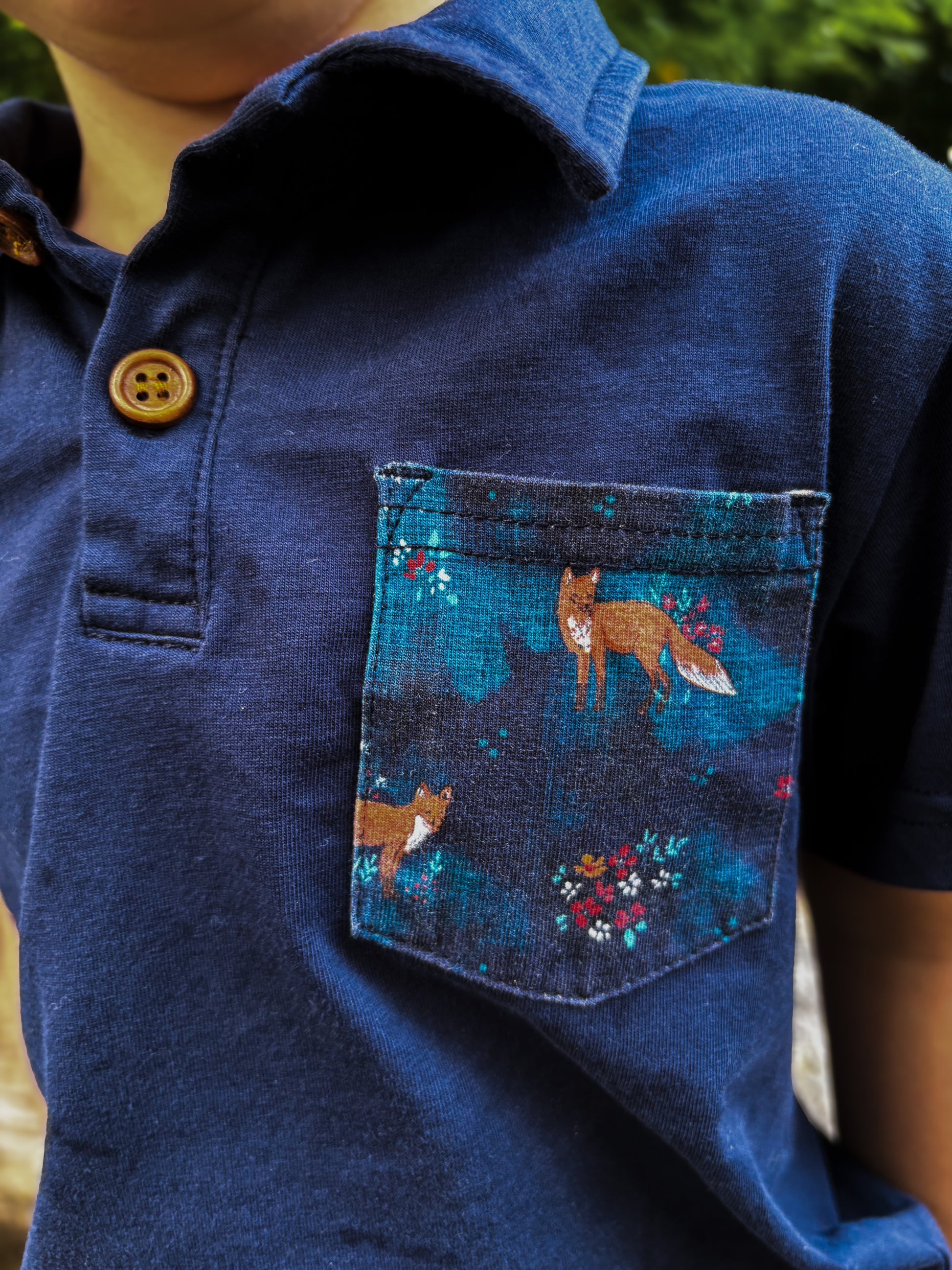 Blue shirt with fox design on pocket.