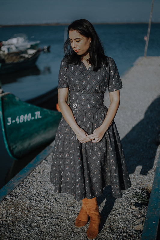 Modest nursing-friendly dark patterned dress by water